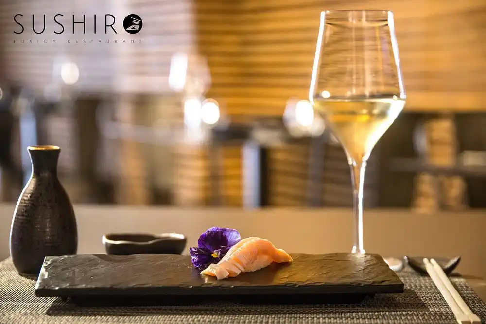 Nigiri di salmone e calice di vino nell'ambiente di Sushiro Fusion