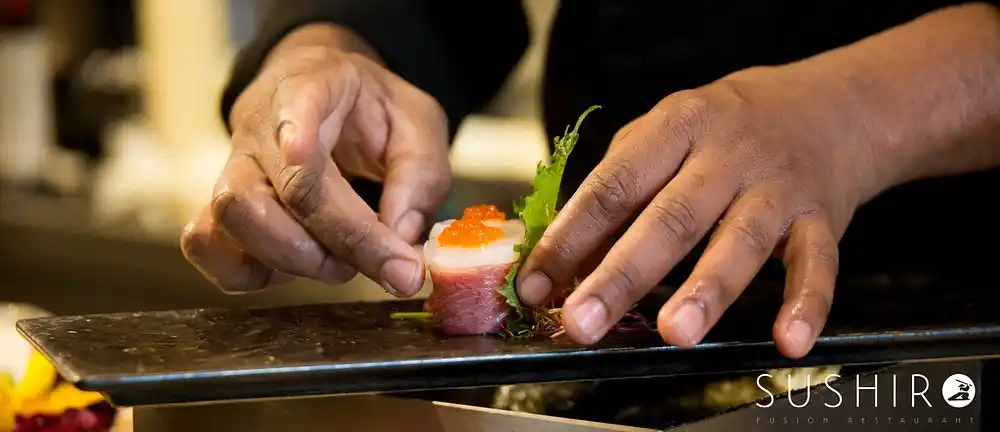Lo chef rifinisce un gunkan di tonno