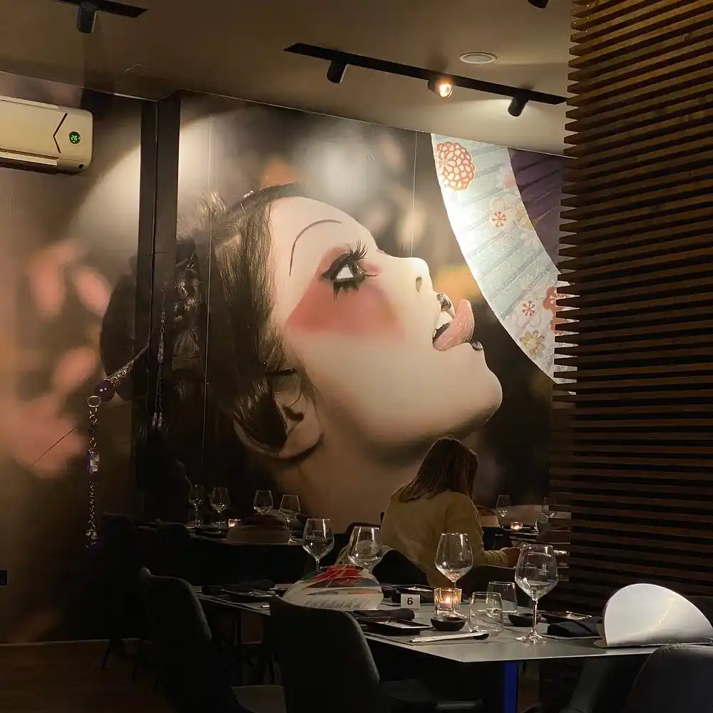 Sala di Sushiro Fusion con parete artistica e tavoli apparecchiati